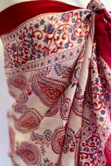 A striking red and white block printed sarong. Measuring 1m 80 x 1m, this handmade sarong features a vibrant block printed motif and makes a stunning cover up on the beach. It does so much more however and is a 'must pack' summer piece. I never go away to the sun without at least three! They are simply so versatile, making wonderful wrap skirts, scarves, tops, beach dresses and head wraps. In short, this beautiful sarong is a real multi-tasker and you can go super chic or super cool in how you style
