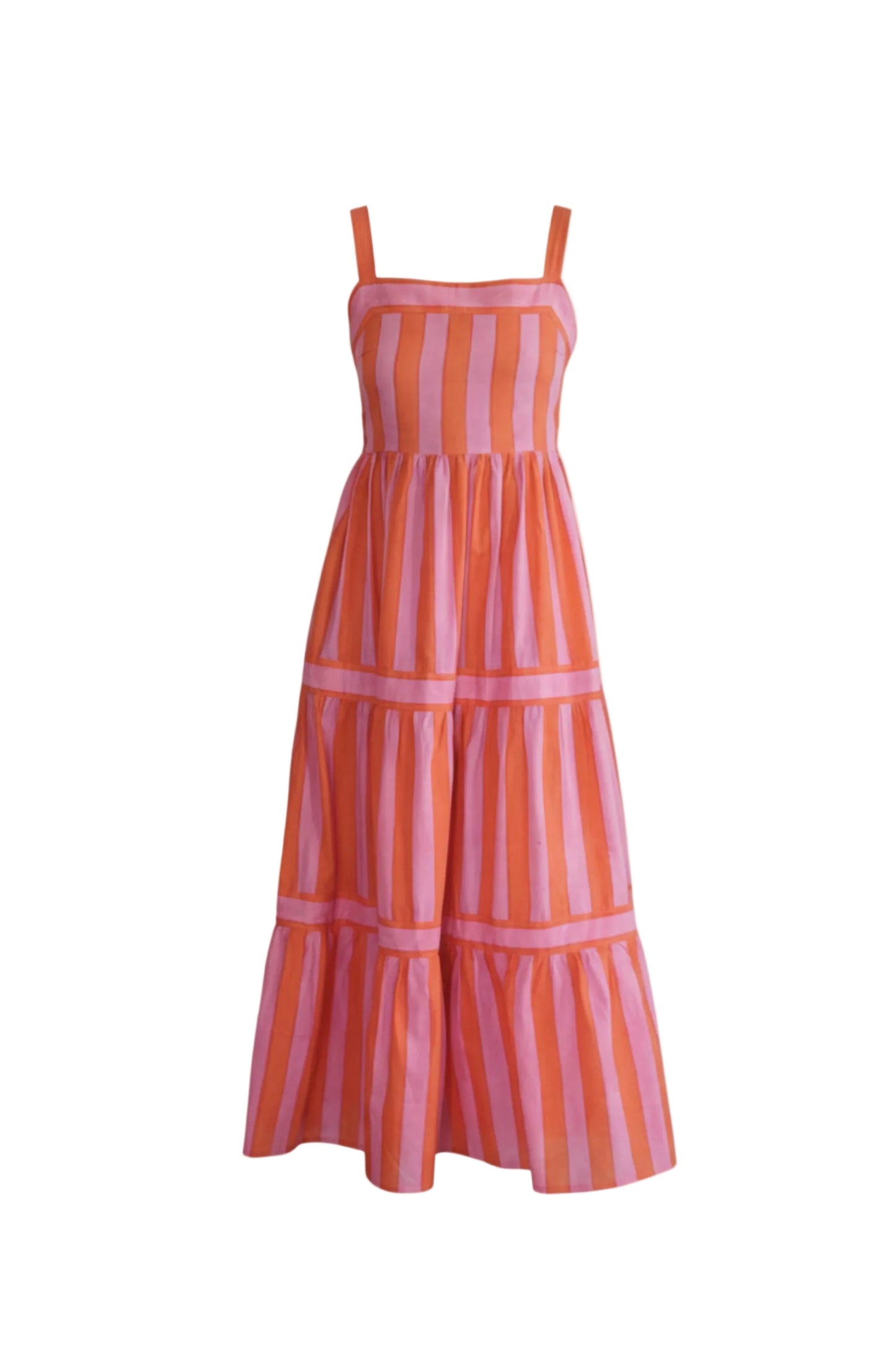 Woman wearing a pink and orange striped dress standing in front of gold circular wall decorations.