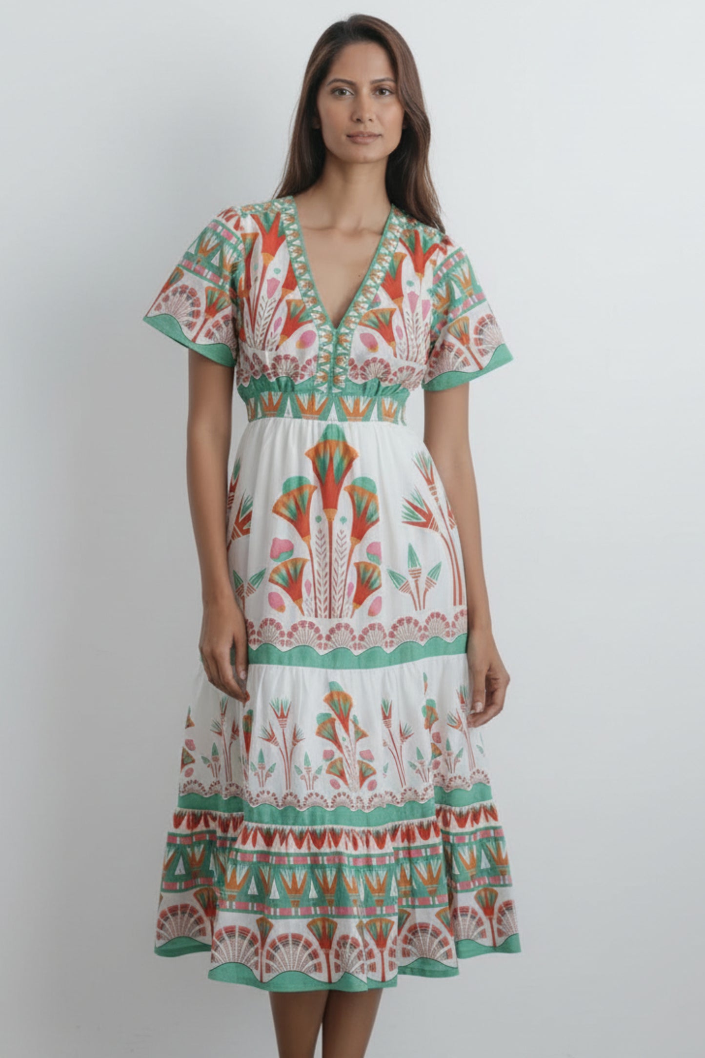 Woman wearing a colorful patterned dress against a white background